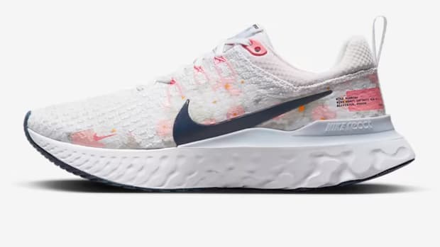 Side view of white and Navy Nike shoe.